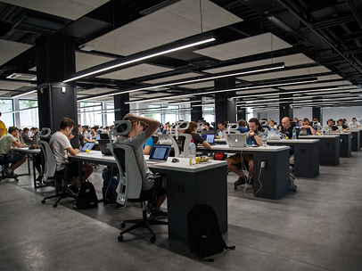 An open-plan office with rows of desks and people working at them.